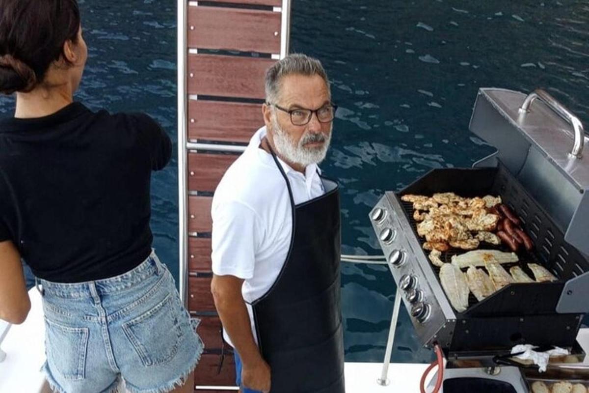un uomo in piedi su una barca accanto a una griglia