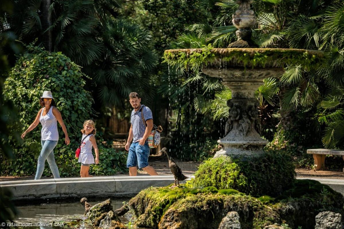 a man and a woman and a child walking by a fountain