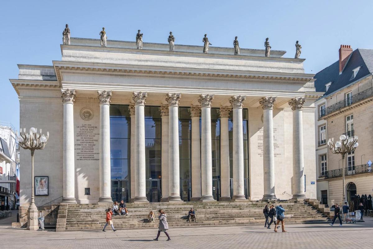 a large building with people walking in front of it