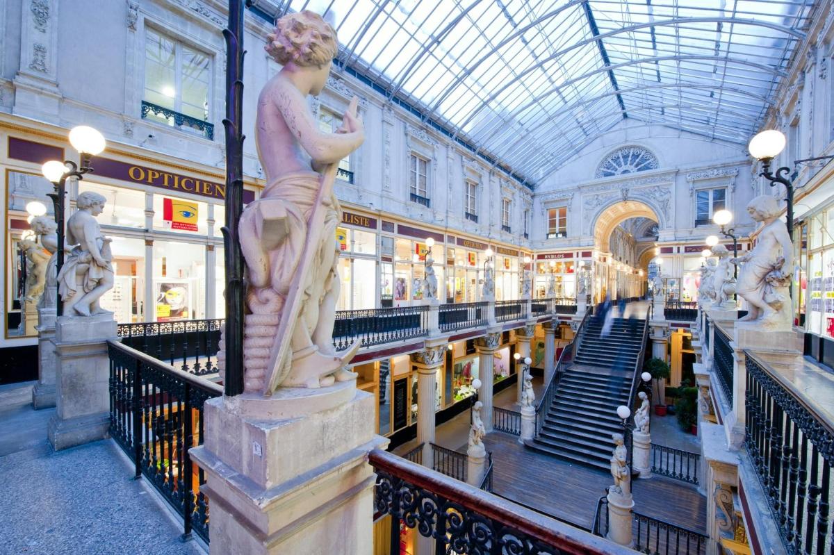 a statue of a woman on a column in a shopping mall