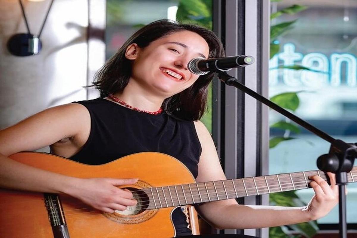 žena hrající na kytaru a mikrofon