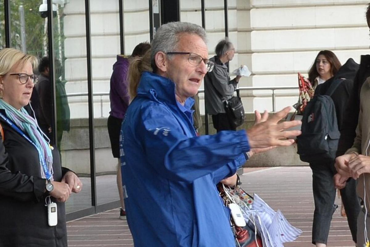 an older man standing in front of a group of people