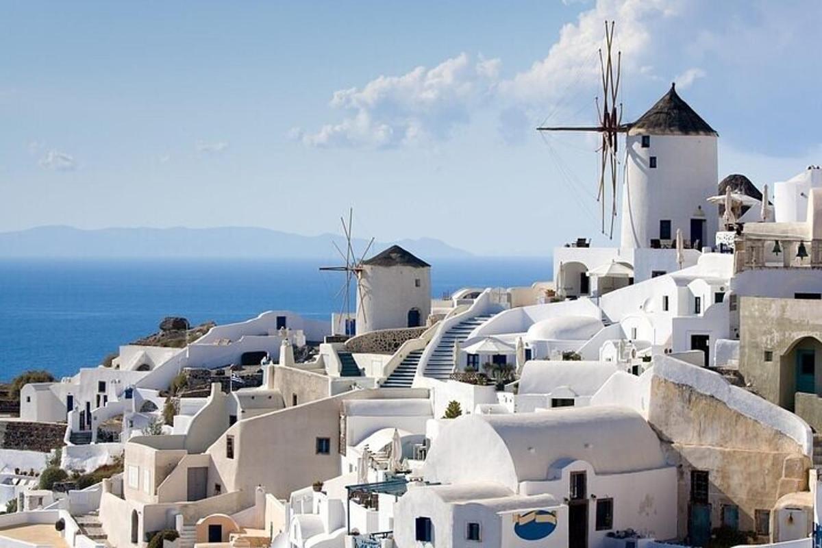 Una vista de un pueblo con edificios blancos y un molino de viento.