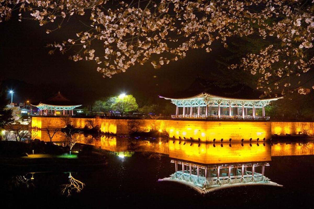 een Chinees gebouw met lichtjes op het water 's nachts