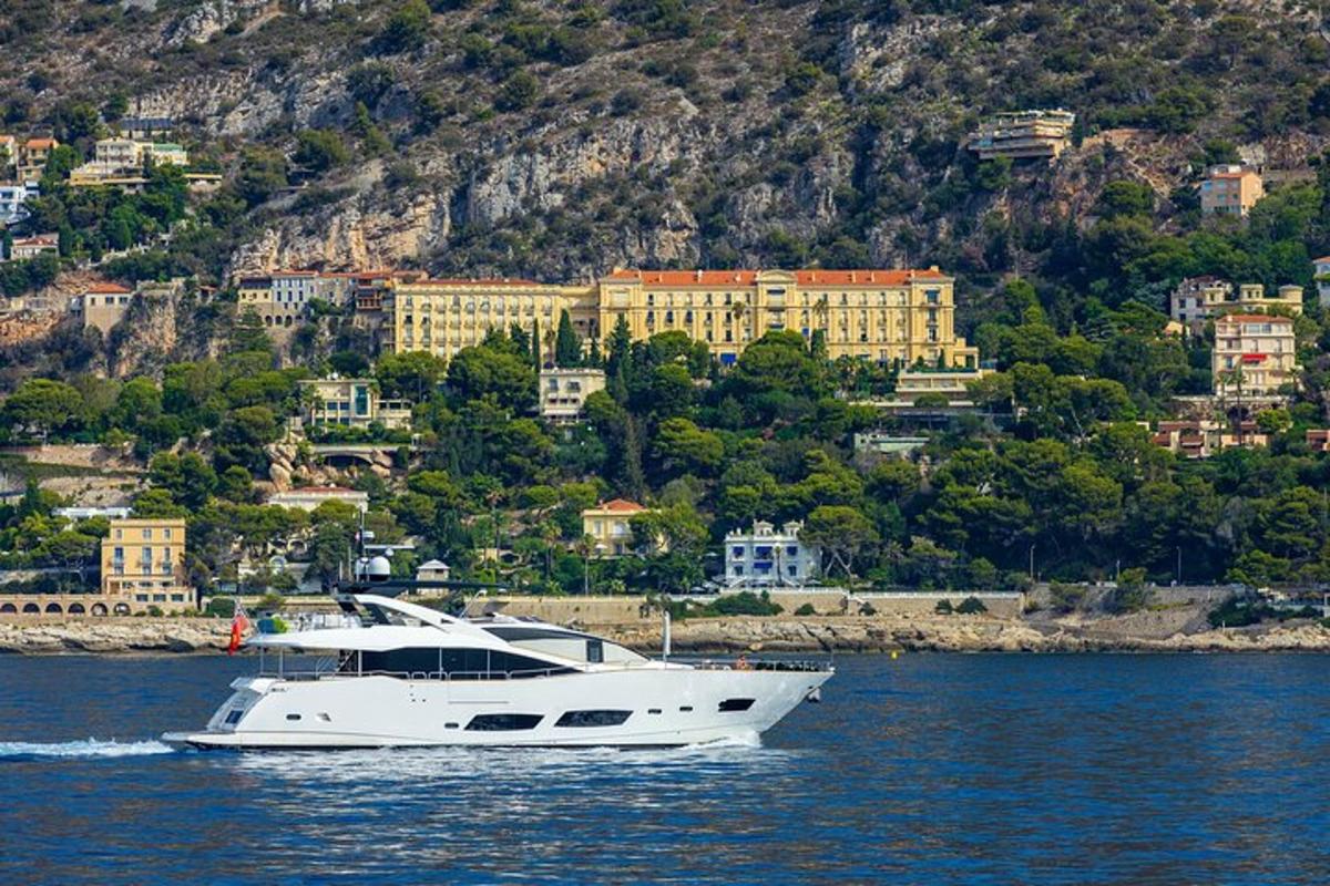 a white boat in the water in front of a city
