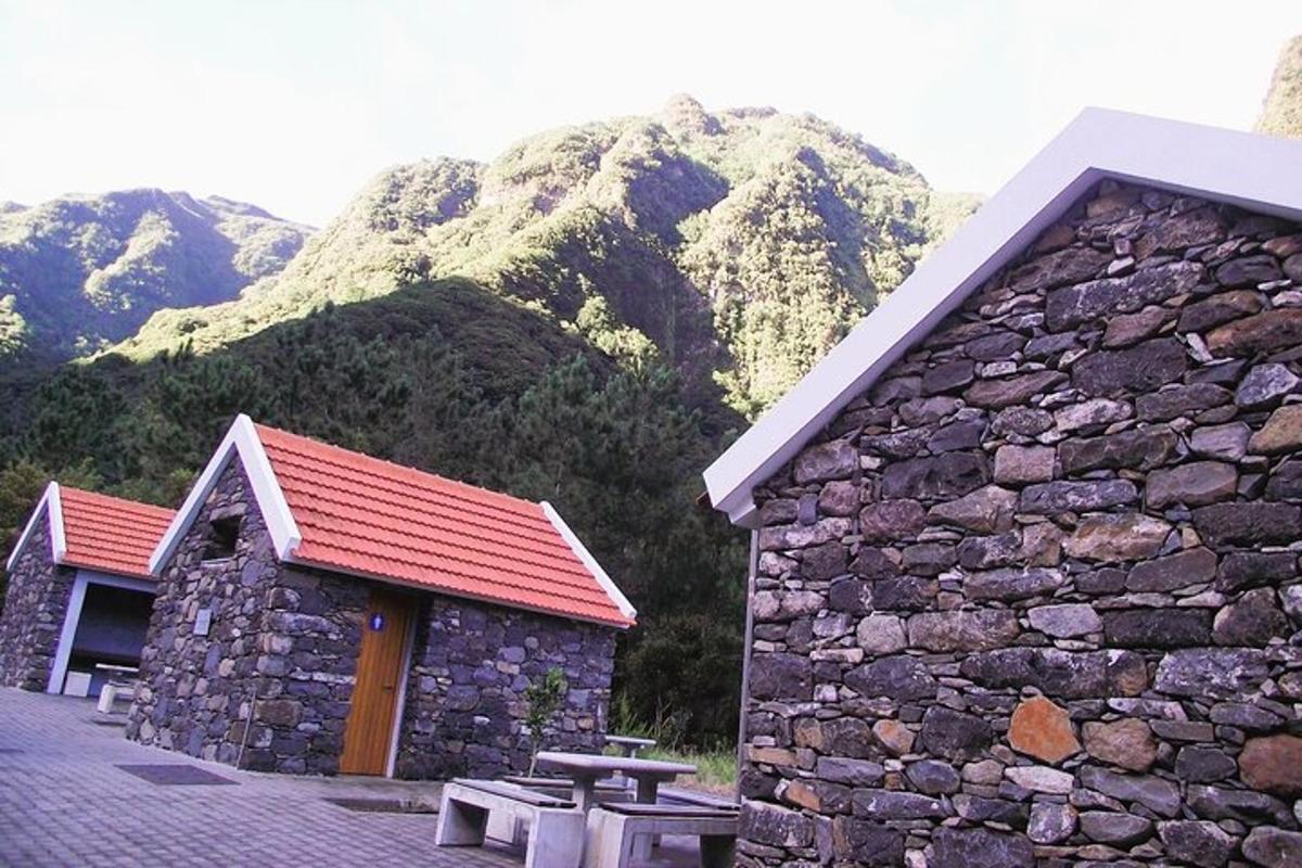 a stone building with a picnic table in front of a mountain
