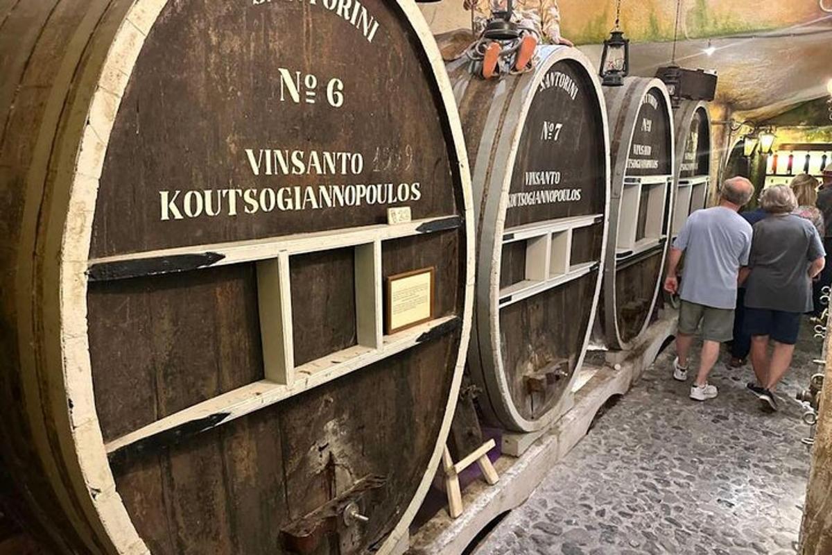skupina lidí, kteří si prohlížejí dva velké vinné sudy