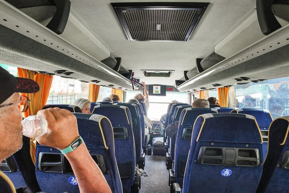 osoba sedící v autobuse s drinkem