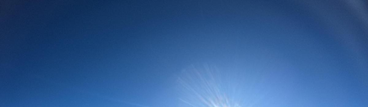 Un cielo azul claro con una cometa volando en él