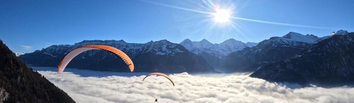 Dos parapentes volando en el cielo sobre las montañas