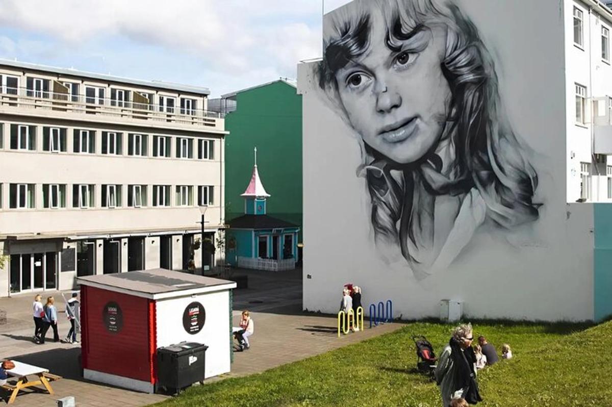 Un mural de una mujer en el costado de un edificio.