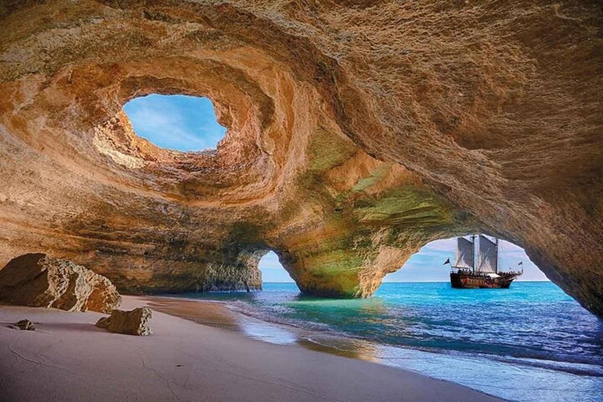 a boat in the water next to a large rock formation