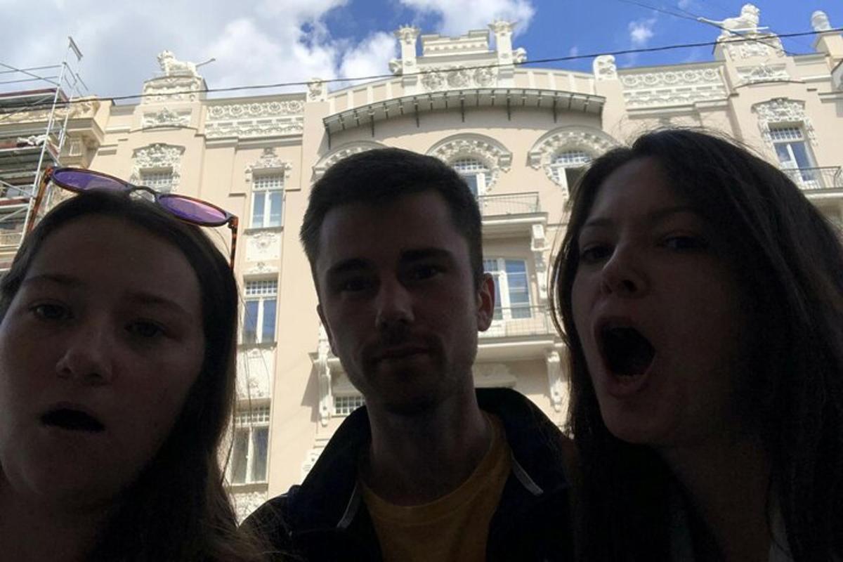 muž a dvě ženy stojící před budovou