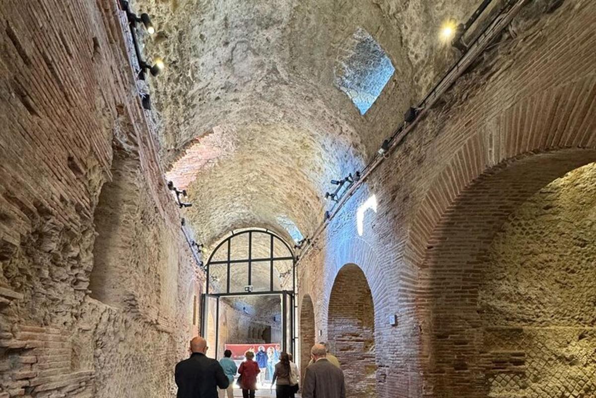 μια ομάδα ανθρώπων που περπατούν μέσα από μια σήραγγα σε ένα κτίριο