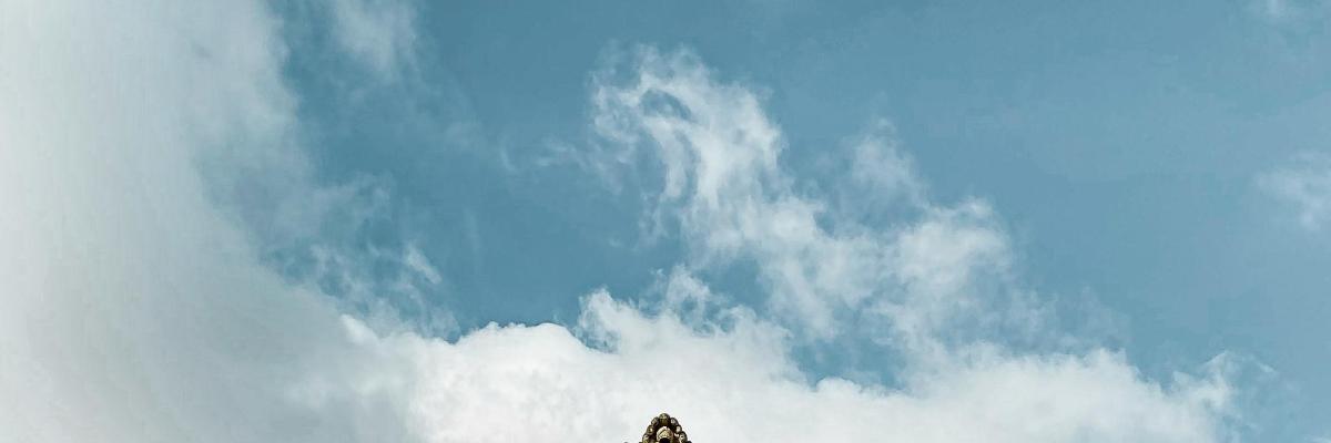 a blue sky with clouds and a mountain