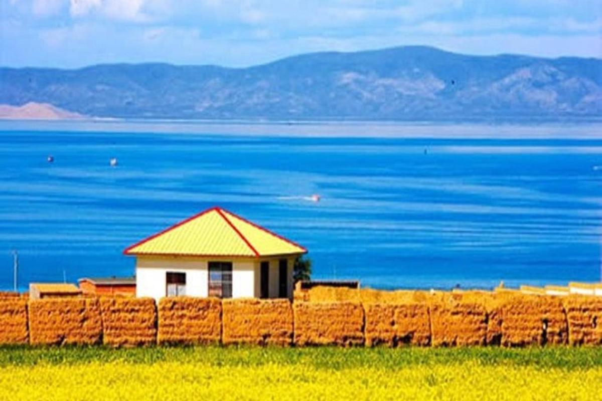 a building behind a fence with the ocean in the background