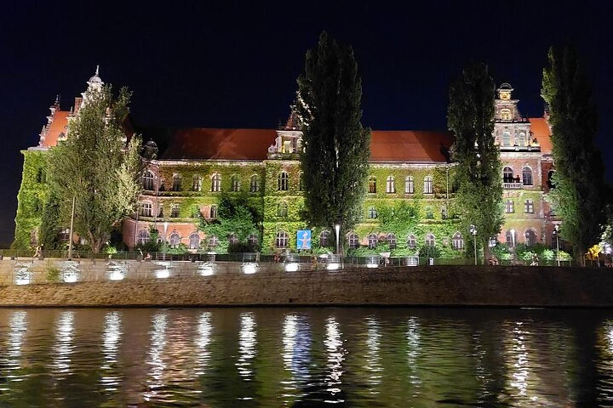 um grande edifício com luzes na água à noite