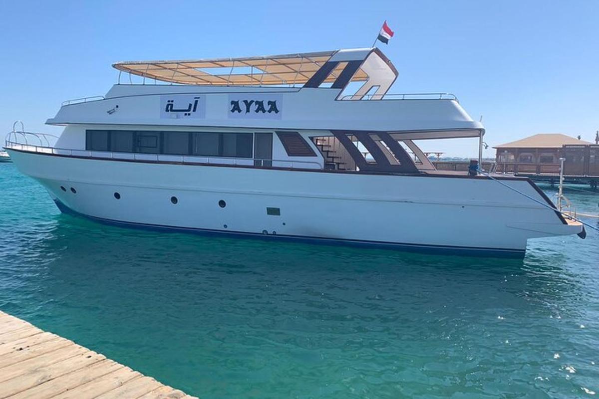una barca bianca ferma nell'acqua accanto a un molo