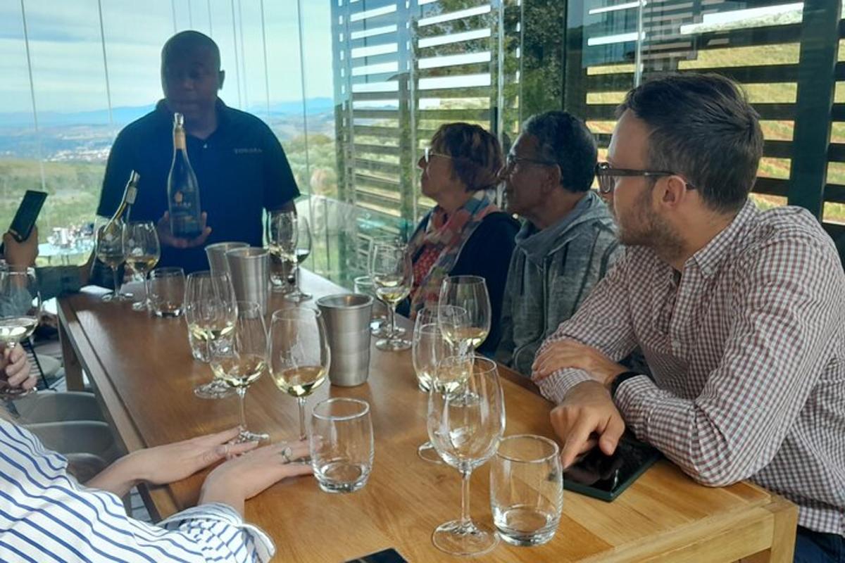 un gruppo di persone sedute a un tavolo con bicchieri di vino