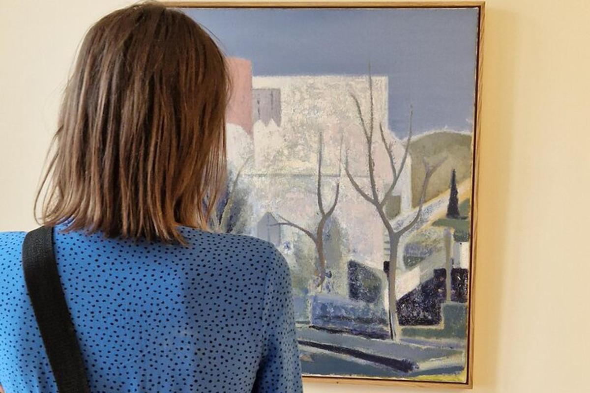 a woman standing in front of a painting on a wall