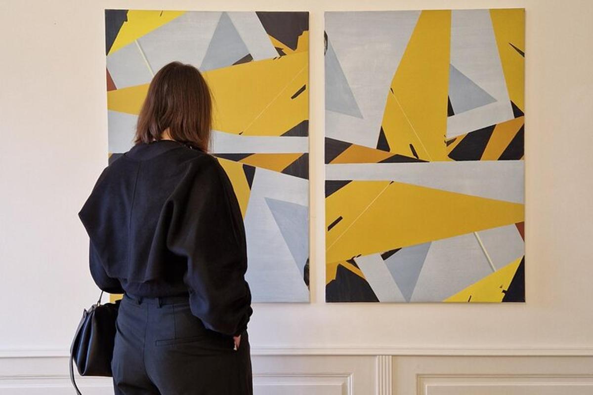 a woman looking at a painting on a wall