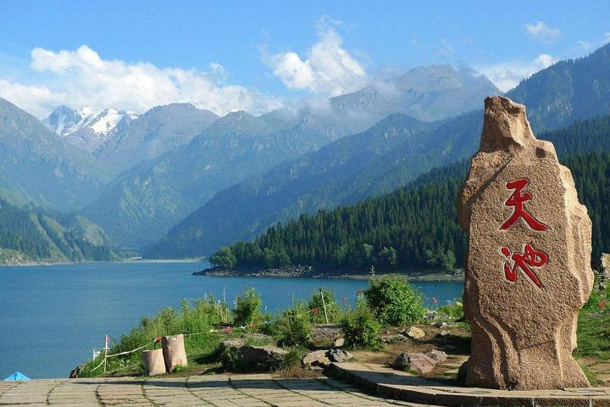 una statua di roccia con una scritta sopra accanto a un lago