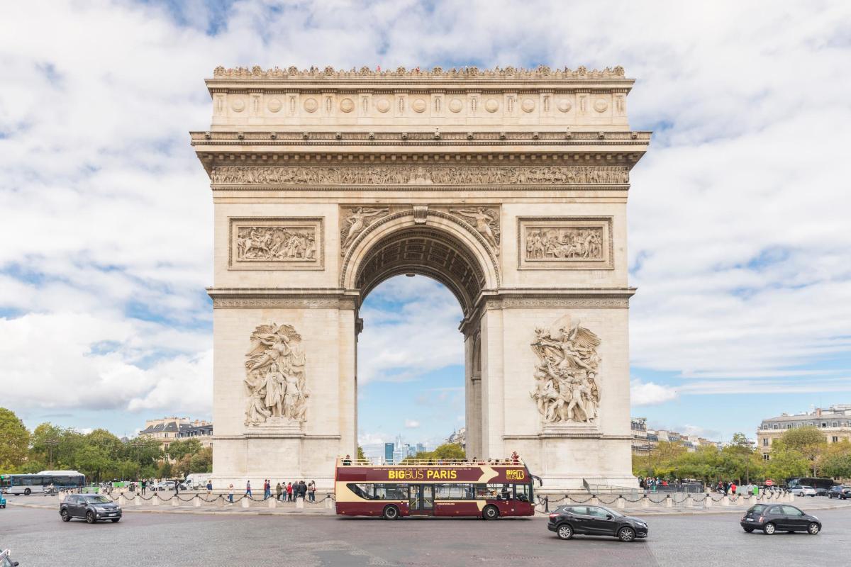 a double decker bus is parked in front of the arch