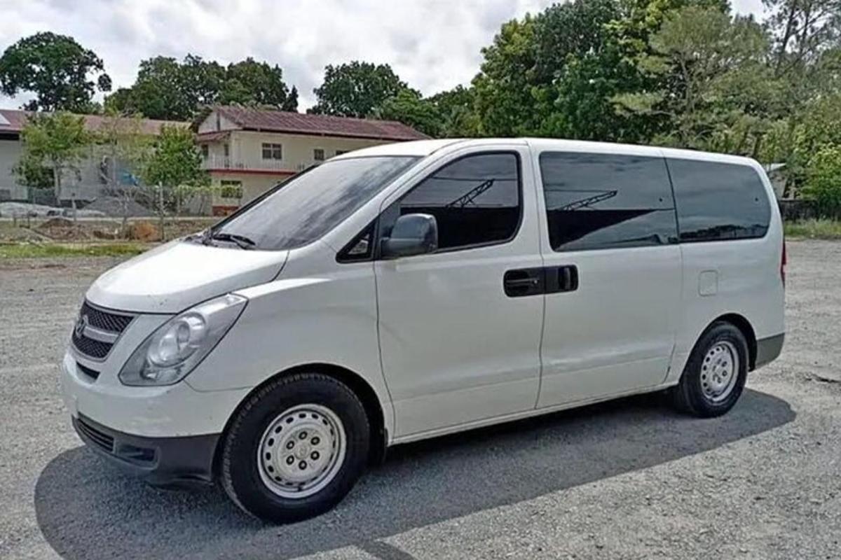 sebuah van putih diletakkan di tempat letak kereta