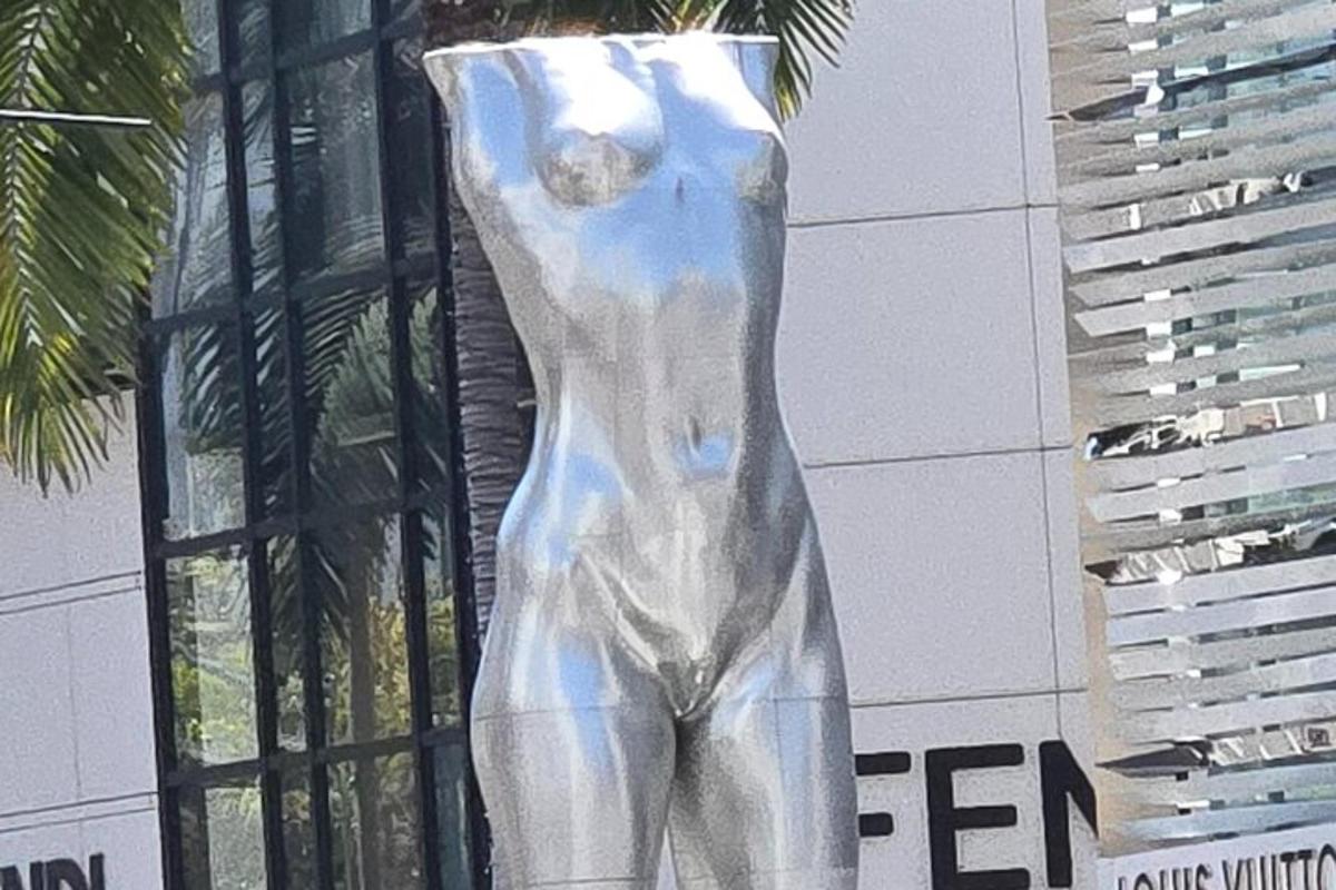 o statuie a unei girafe stând în fața unei clădiri