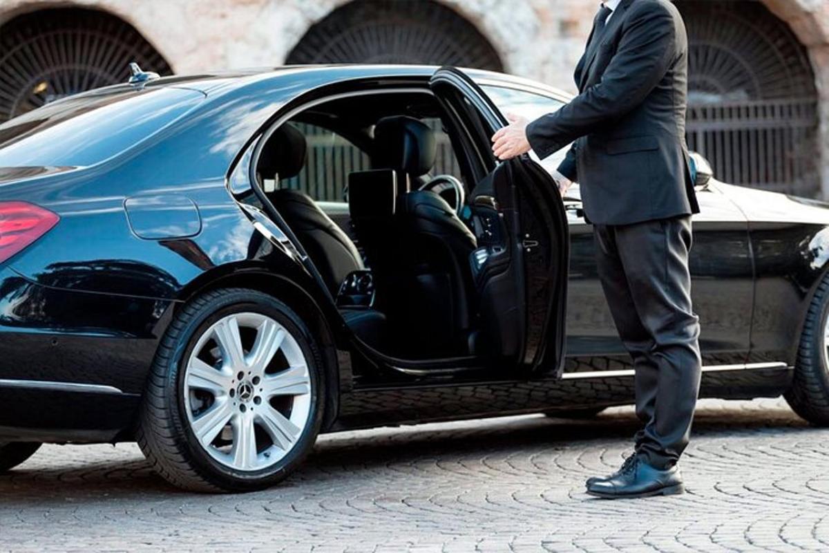Un hombre con traje subiéndose a un coche.