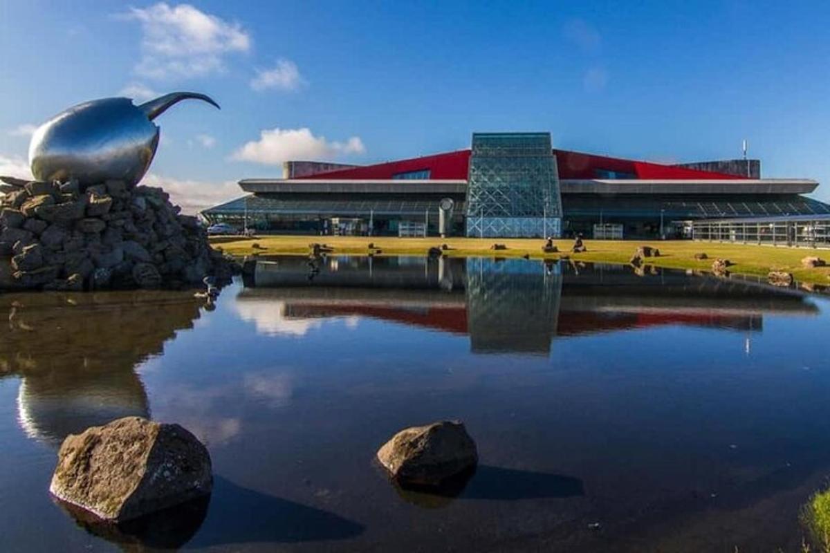 Un gran edificio con una estatua de pájaro en el agua.
