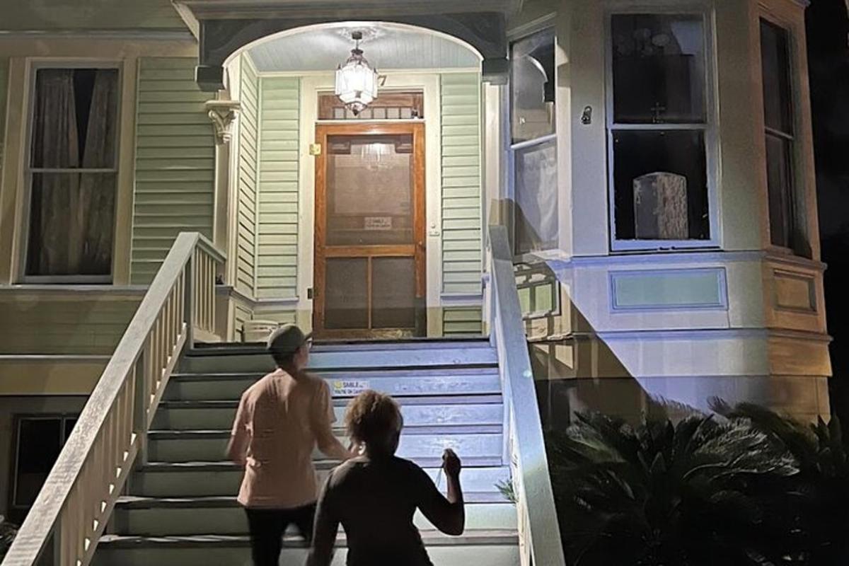 two women walking up the stairs of a house