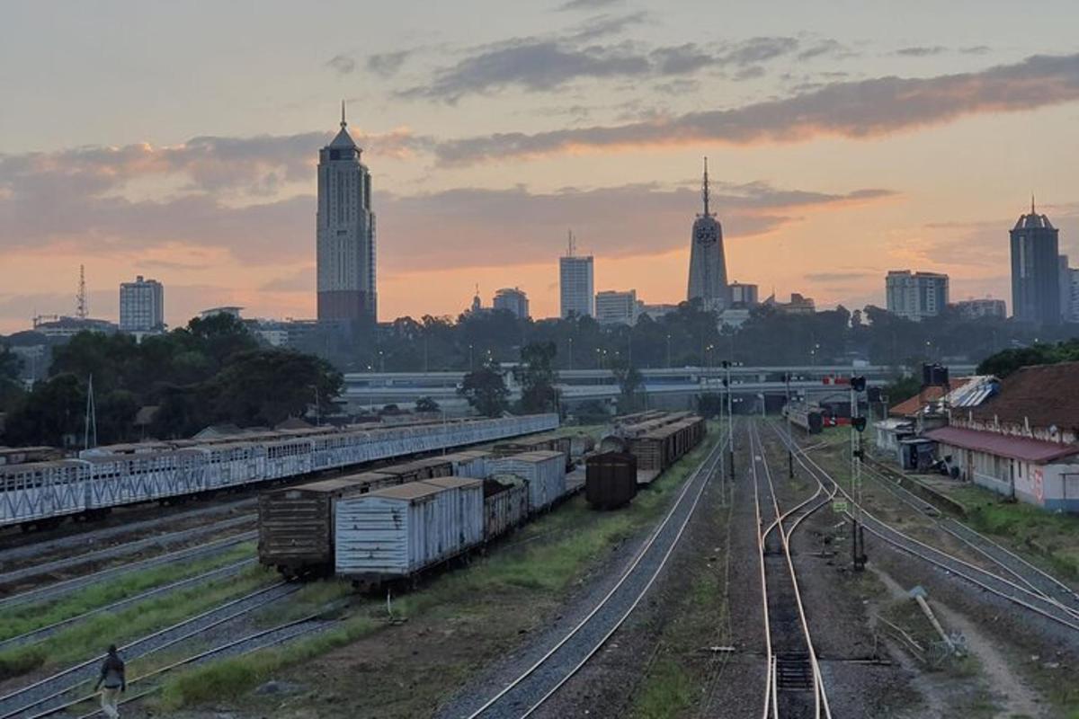 um grupo de trilhos de trem com uma cidade ao fundo