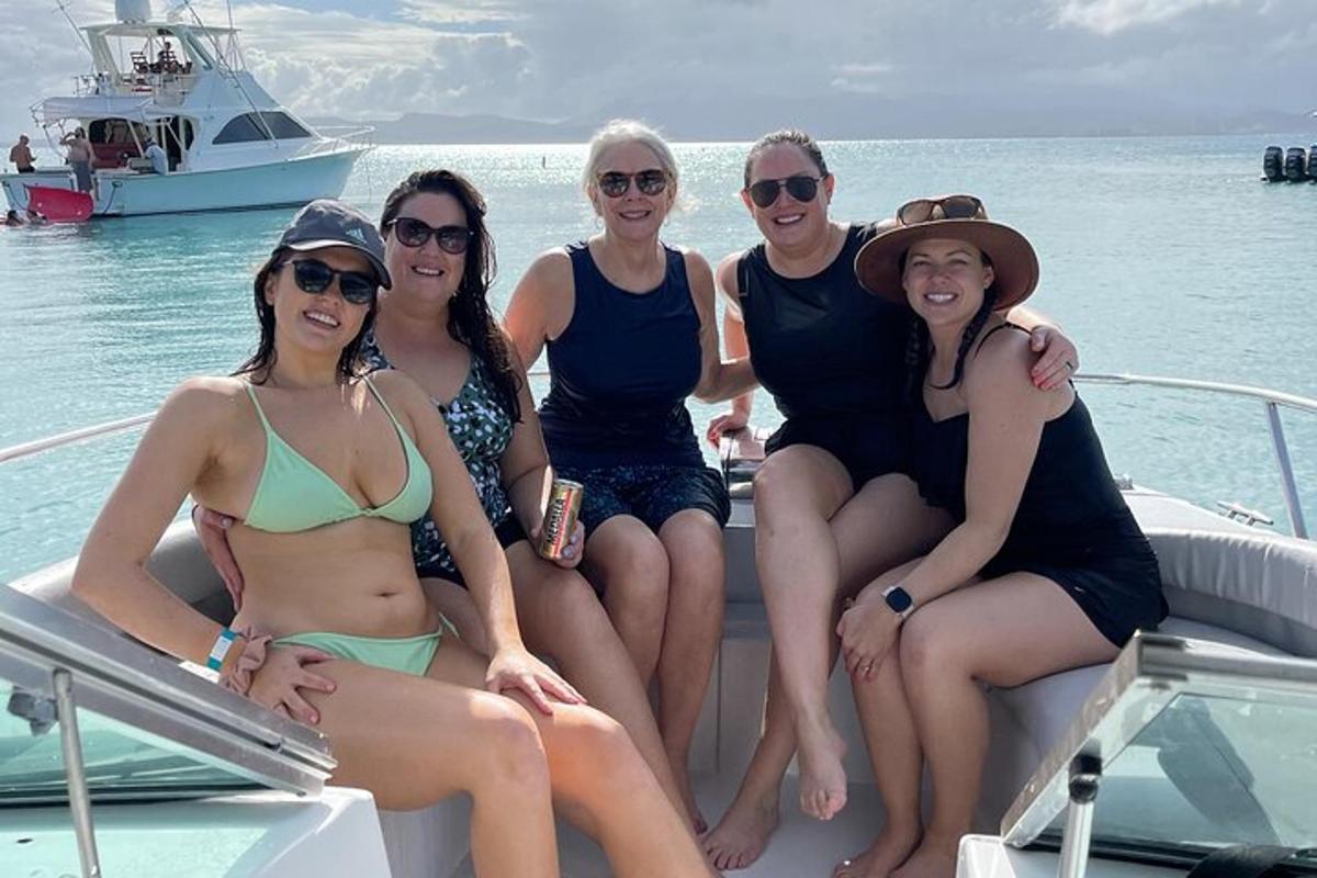 a group of women sitting on a boat in the water