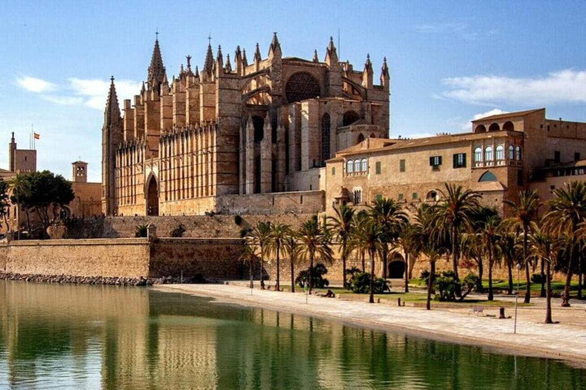 a cathedral with palm trees in front of a body of water