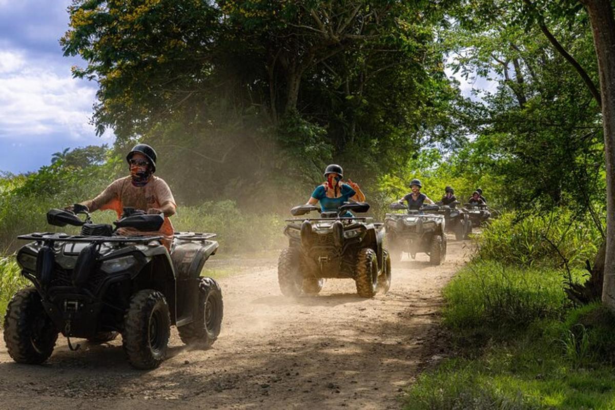 a group of people riding atvs on a dirt road