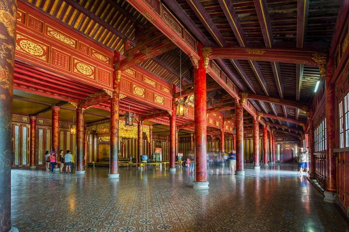Un gran edificio con columnas rojas y gente dentro.