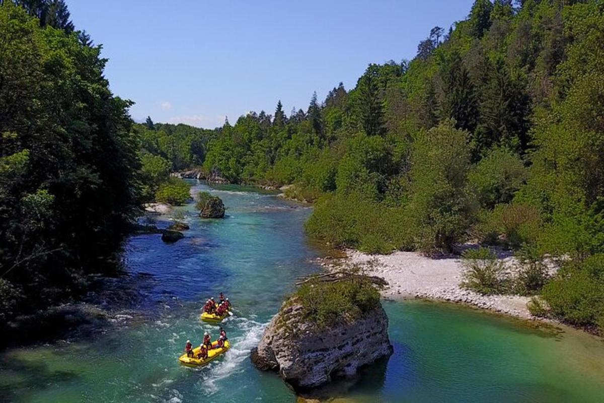three people in rafts on a river with trees