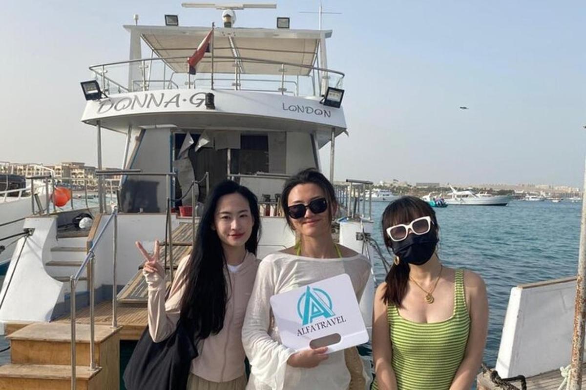 three women standing on a boat with a sign