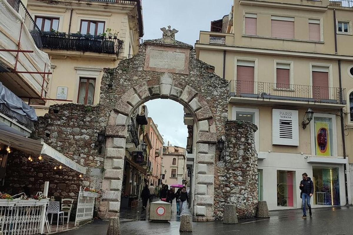 isang archway sa gitna ng isang lungsod na may mga gusali