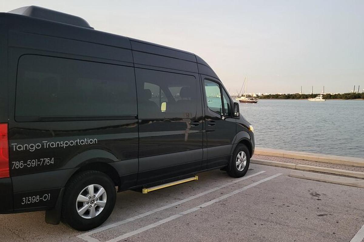 en svart varebil parkert ved siden av et vann