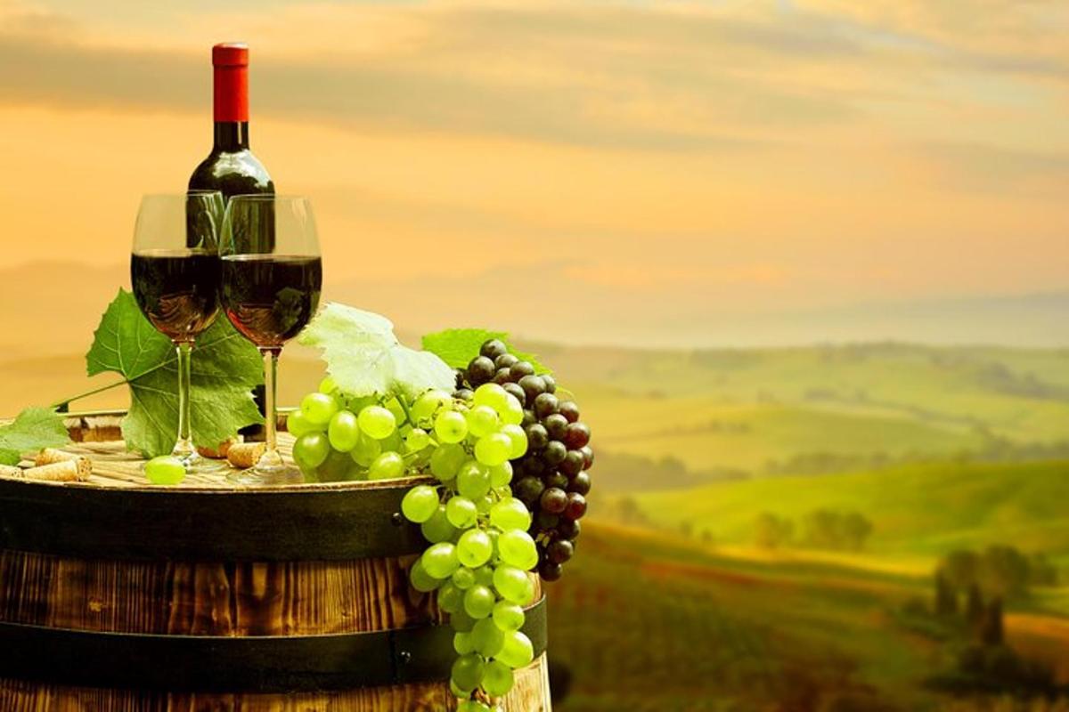 uma garrafa de vinho e um cacho de uvas