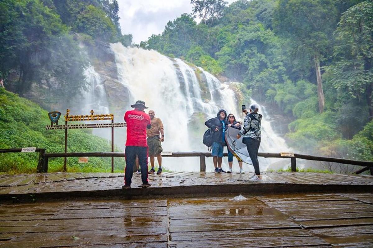 sekumpulan orang berdiri di hadapan air terjun
