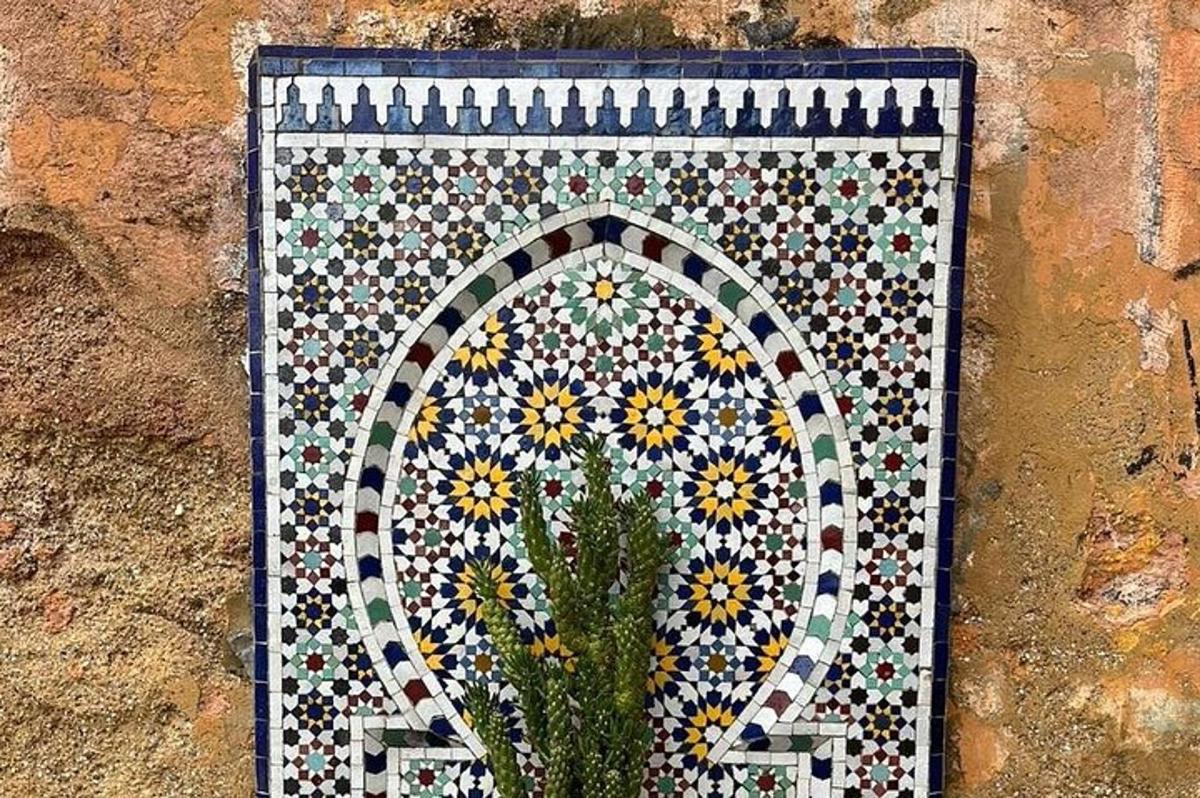 une mosaïque sur le côté d'un mur avec une plante
