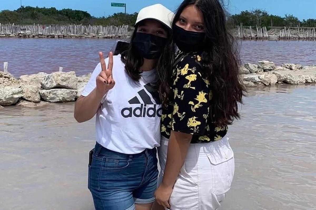 dua wanita memakai topeng berdiri di sebelah air