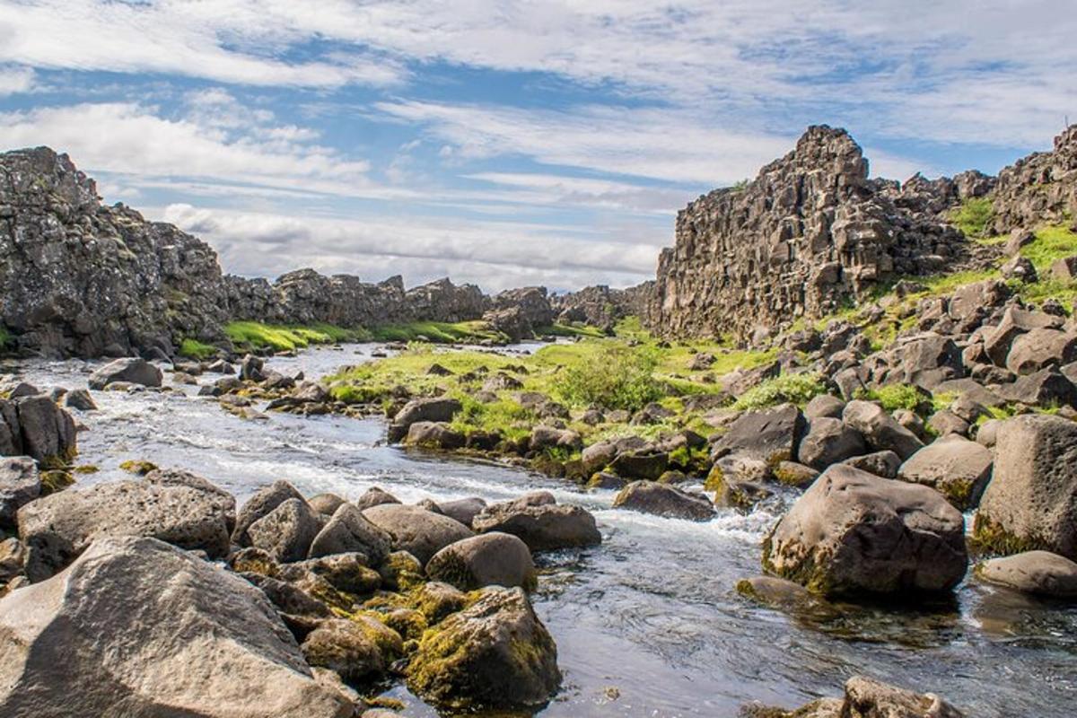 a river with rocks in a rocky area with a mountain