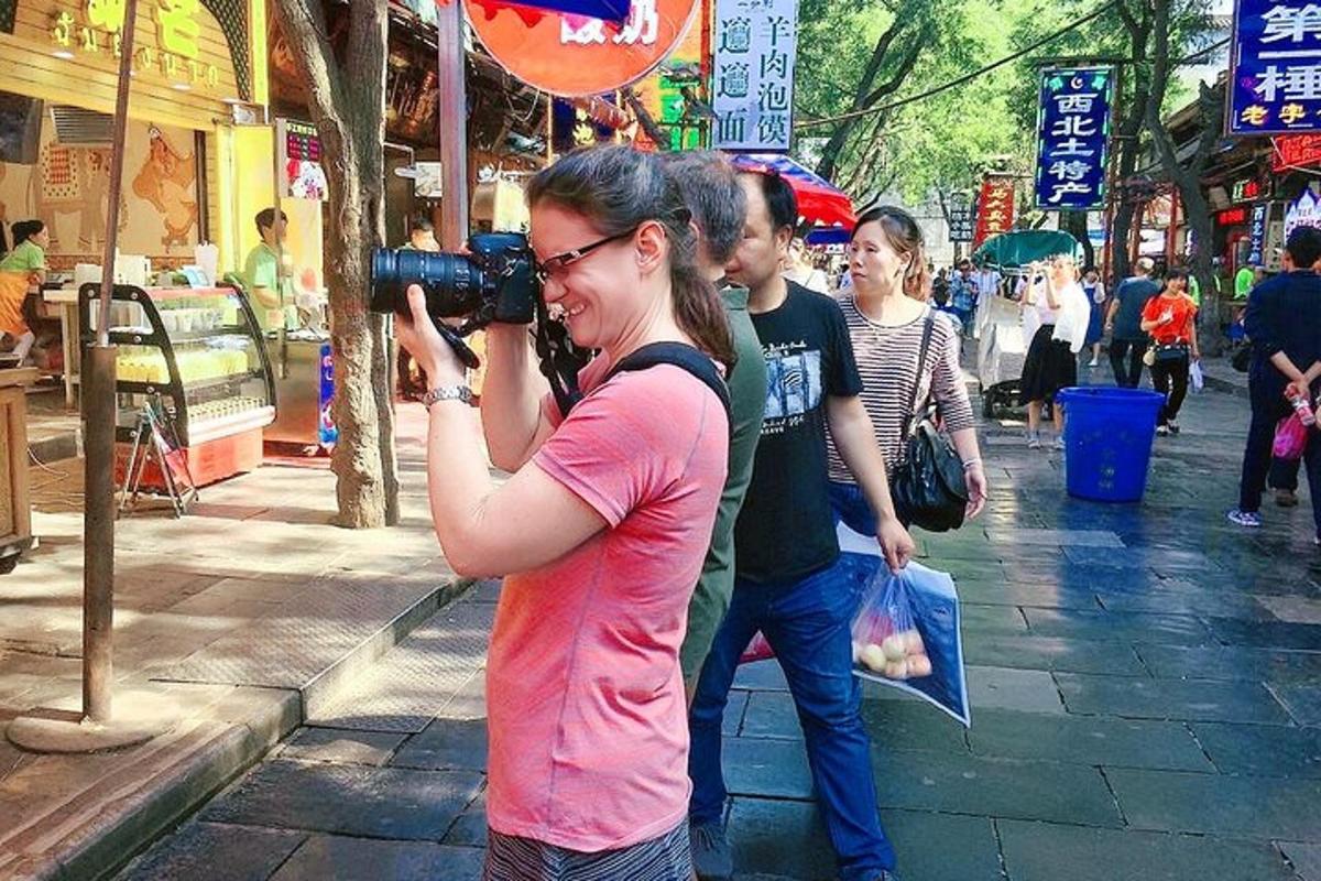 a woman taking a picture with a camera on a street