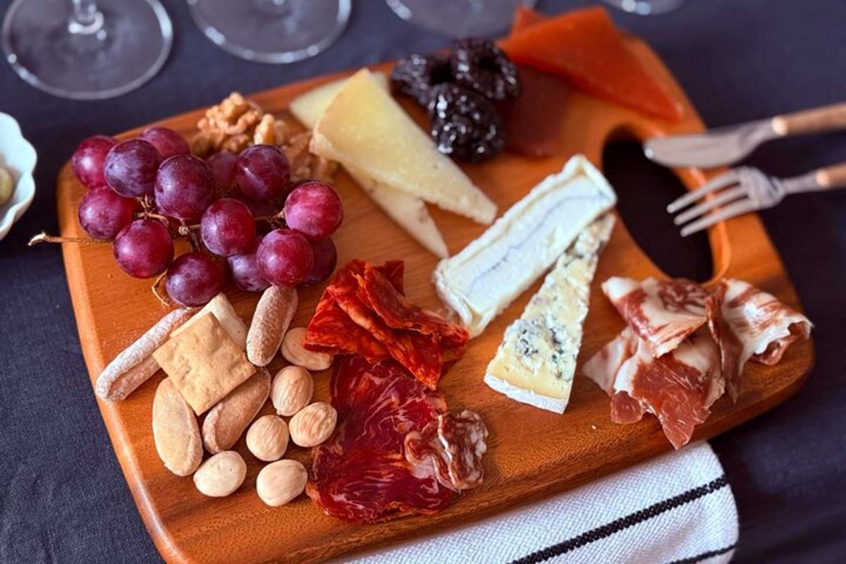 un tagliere con formaggio, uva e noci