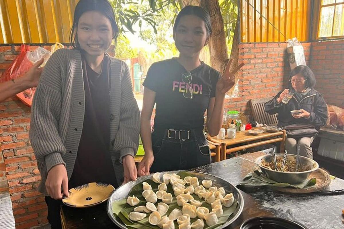 due donne in piedi accanto a un tavolo con un piatto di cibo