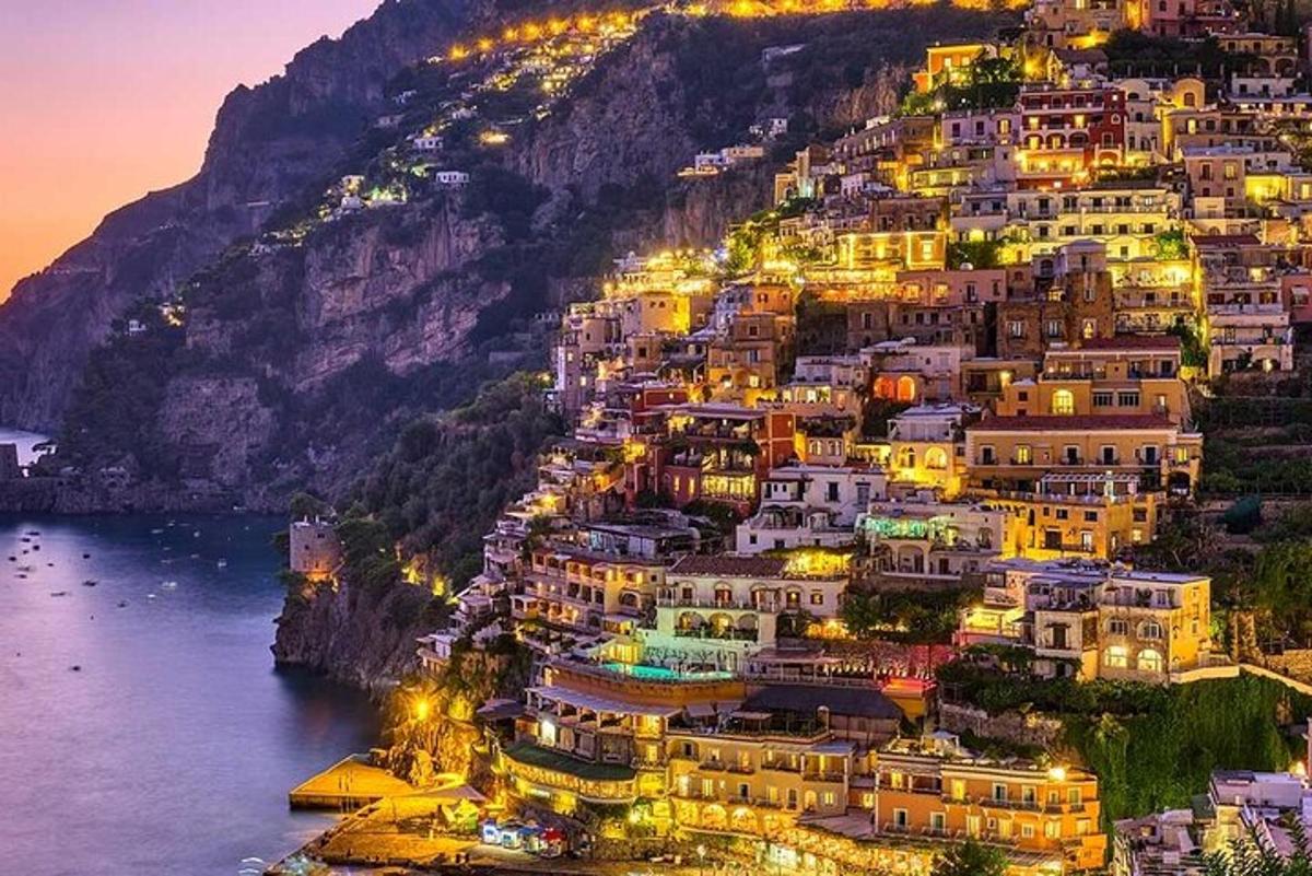 a positano village on the side of a mountain at night